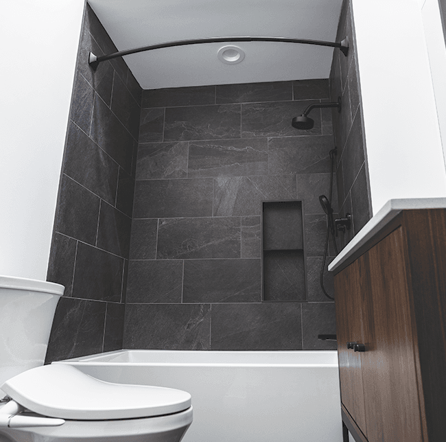bathroom shower with large dark grey tiling
