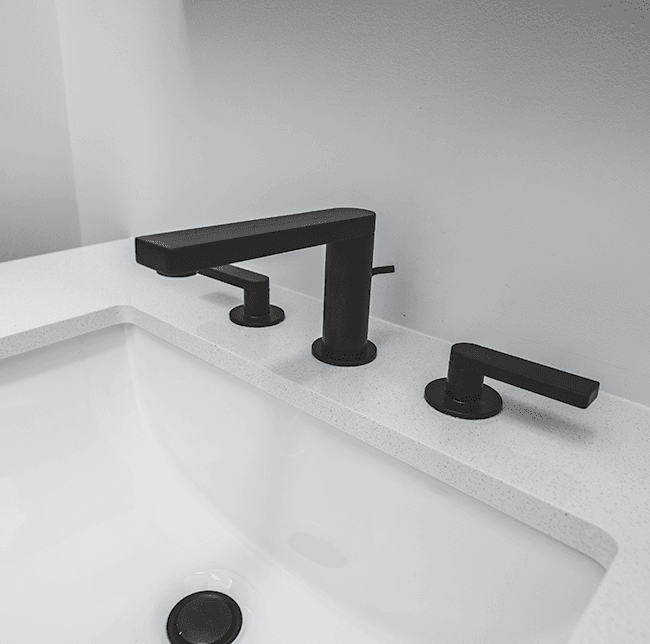 black industrial style faucets on white bathroom sink