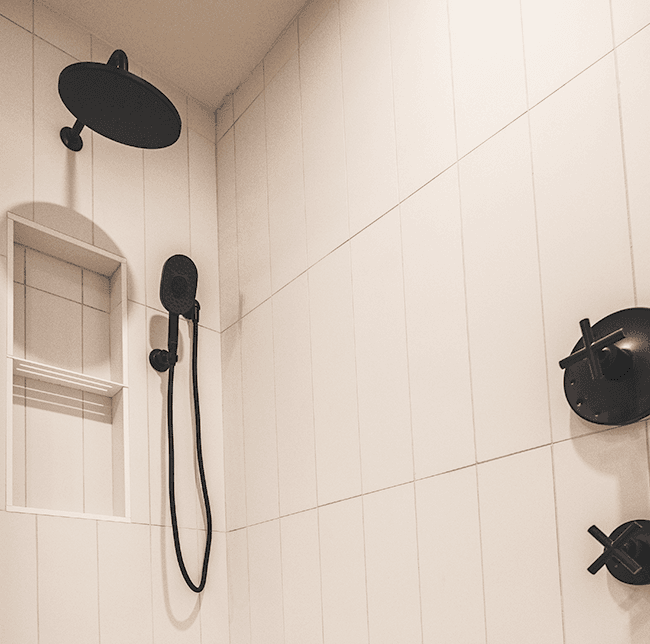 Bathroom Details with black showerhead and white vertical tiling