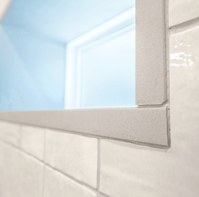closeup of bathroom window corner with emphasis on the tile work