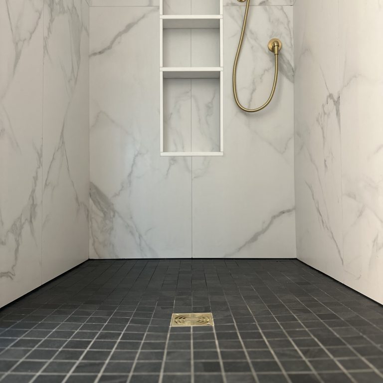 bathroom with marble walls and dark gray tiles