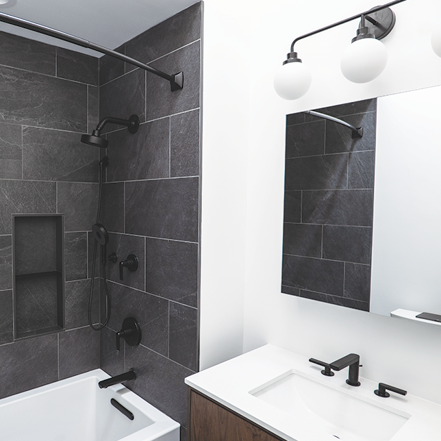 bathroom with white walls and shower with dark gray tiles