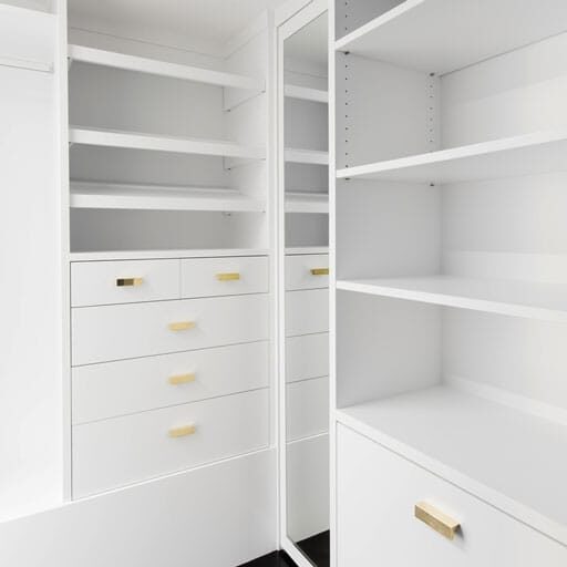 white-bookcase-2 White built-in closet with open shelving, drawers, and gold hardware, including a mirrored door