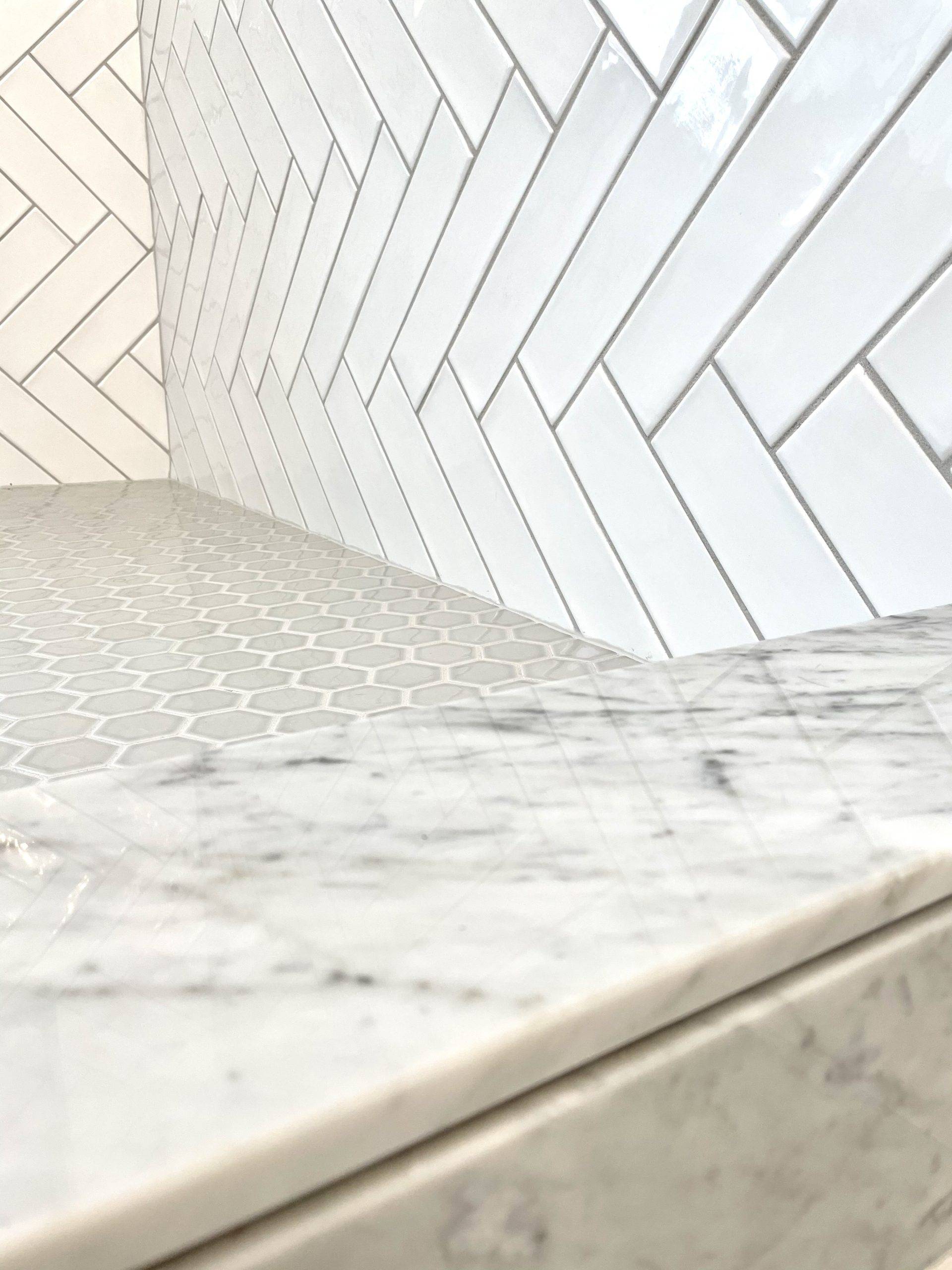 Close-up of herringbone tile pattern with marble countertop.