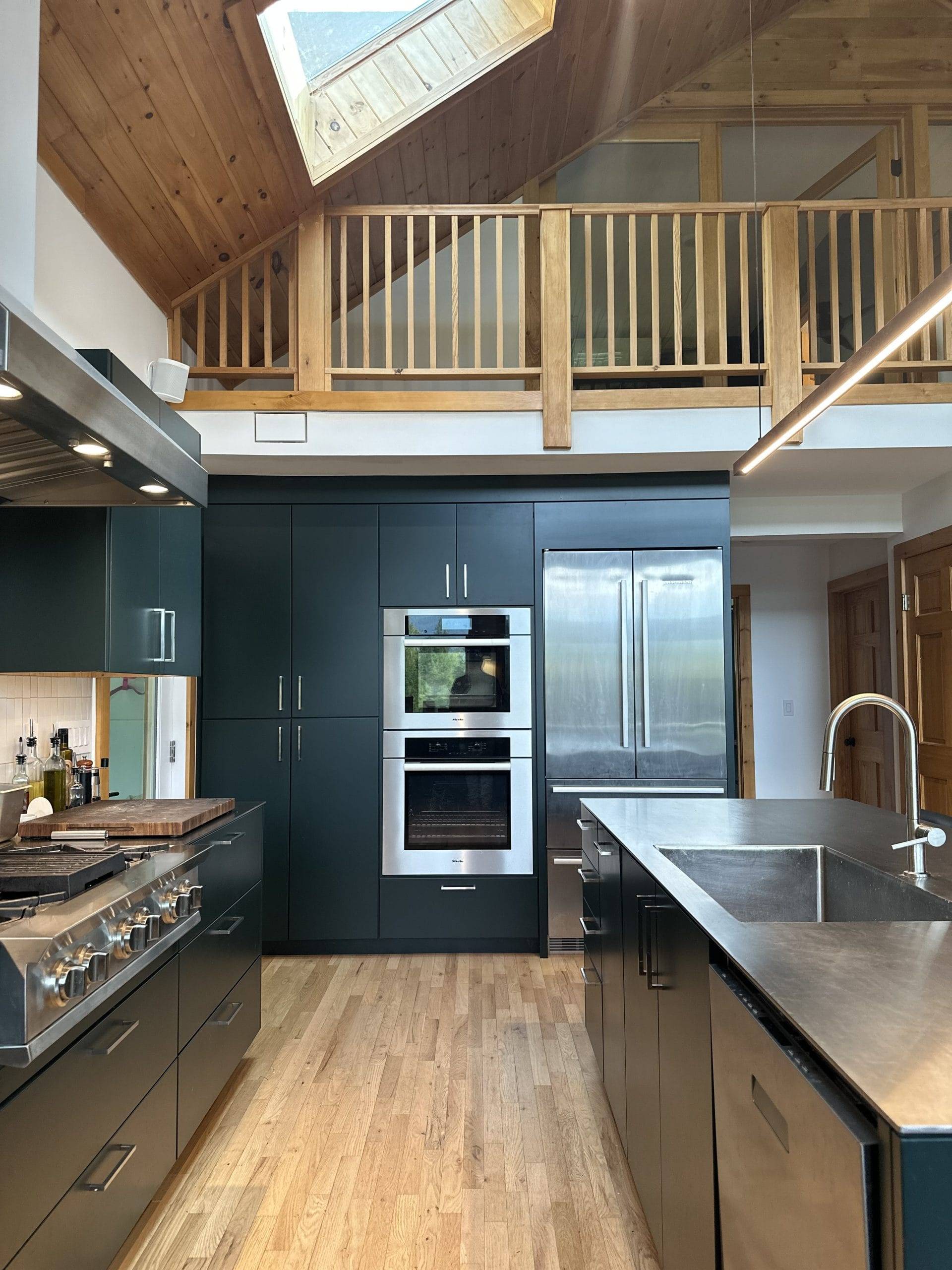 A green painted modern-style farmhouse kitchen with a unique twist of Stainless Steel countertops