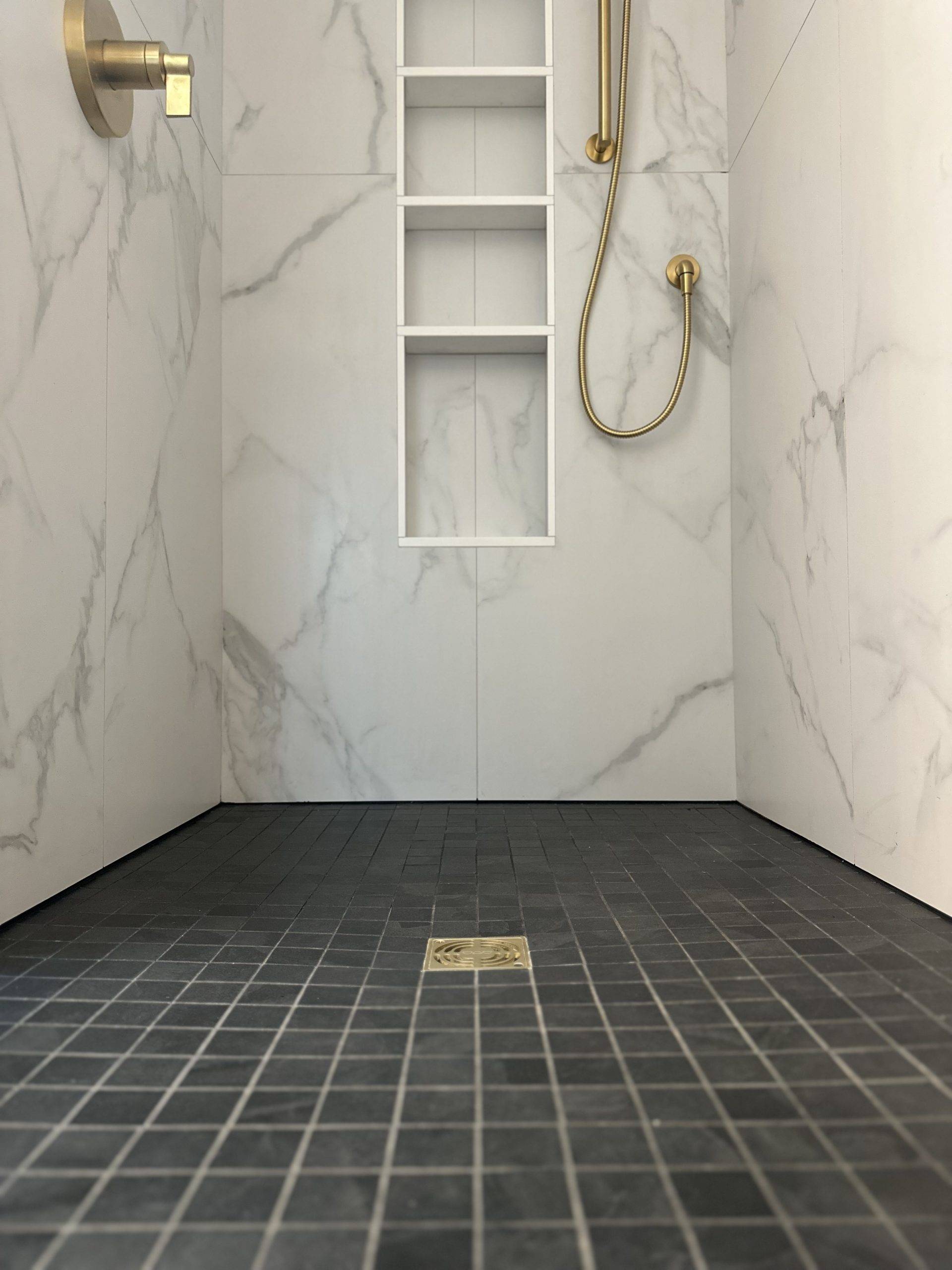 bathroom with marble walls and dark gray tiles