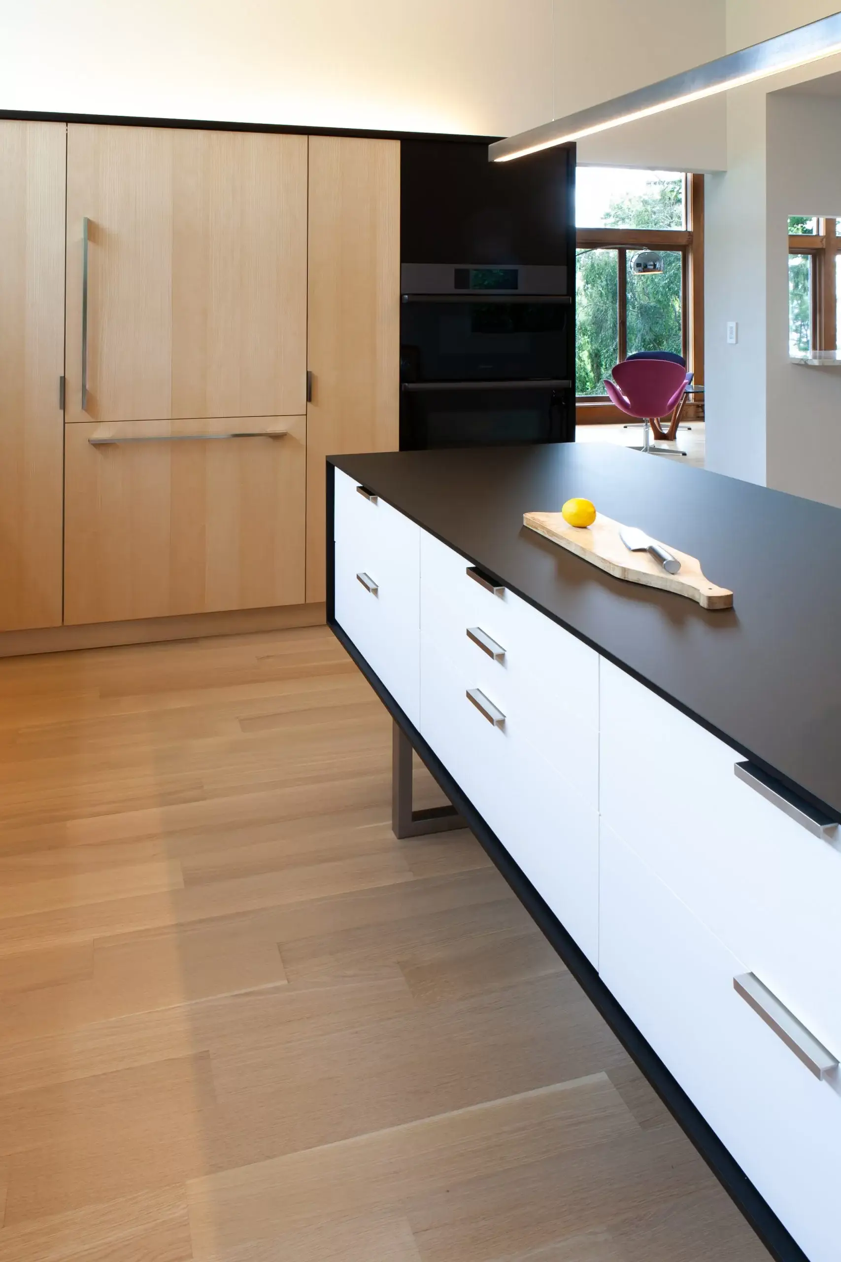 kitchen island with black and white finish on ash wood flooring
